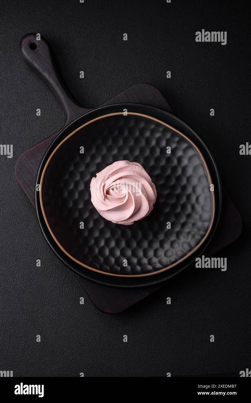 Köstlicher süßer Marshmallow auf dunklem Betonhintergrund Stockfoto