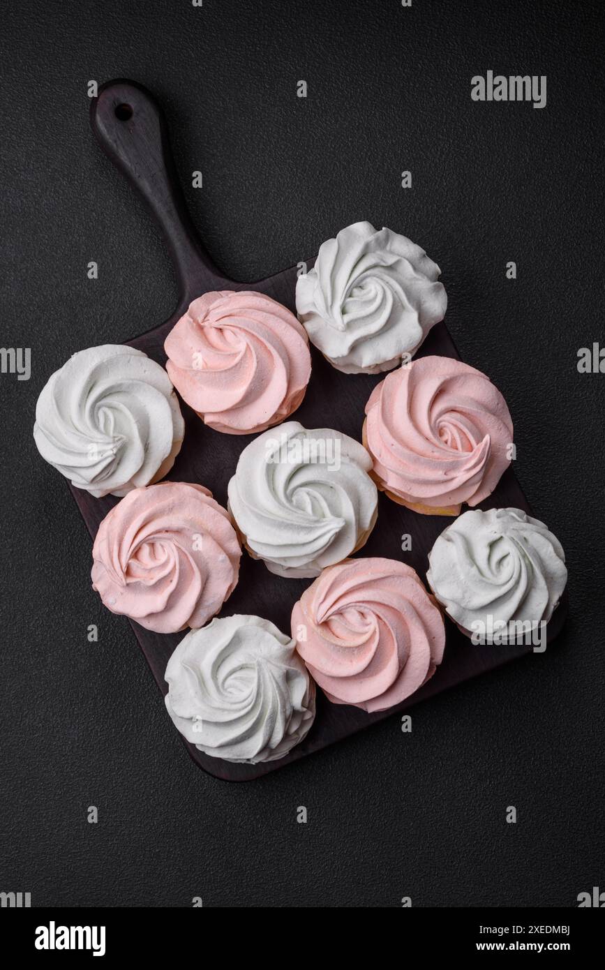 Köstliches süßes mehrfarbiges Marshmallow auf dunklem Betonhintergrund Stockfoto