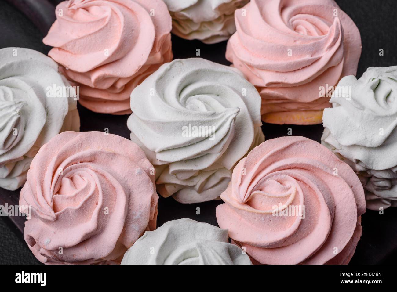 Köstliches süßes mehrfarbiges Marshmallow auf dunklem Betonhintergrund Stockfoto