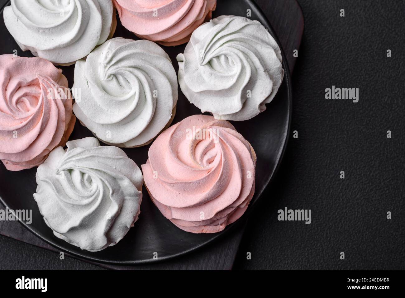 Köstliches süßes mehrfarbiges Marshmallow auf dunklem Betonhintergrund Stockfoto