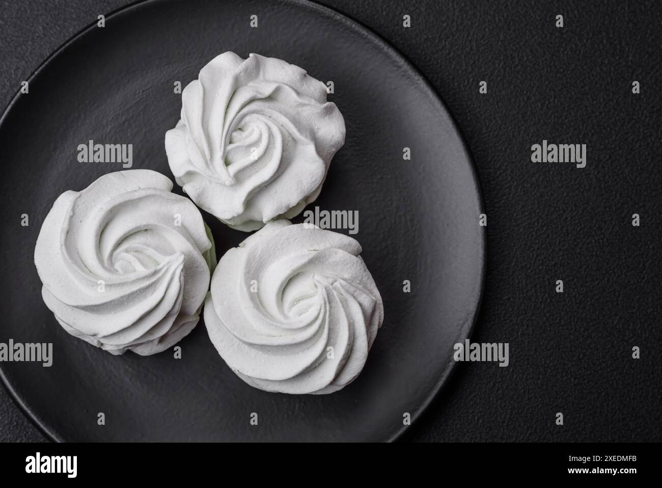 Köstlicher süßer Marshmallow auf dunklem Betonhintergrund Stockfoto