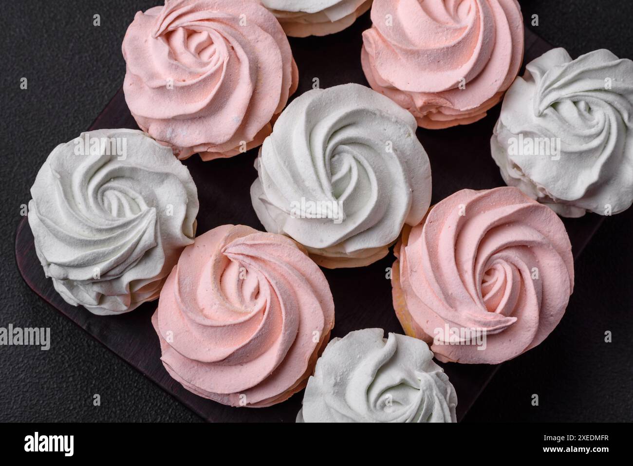 Köstliches süßes mehrfarbiges Marshmallow auf dunklem Betonhintergrund Stockfoto