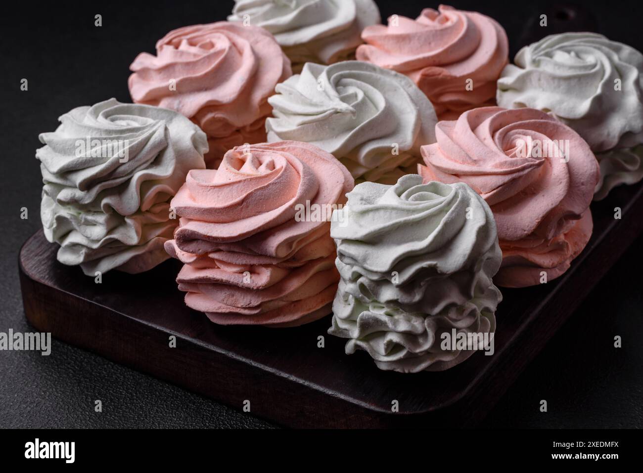 Köstliches süßes mehrfarbiges Marshmallow auf dunklem Betonhintergrund Stockfoto