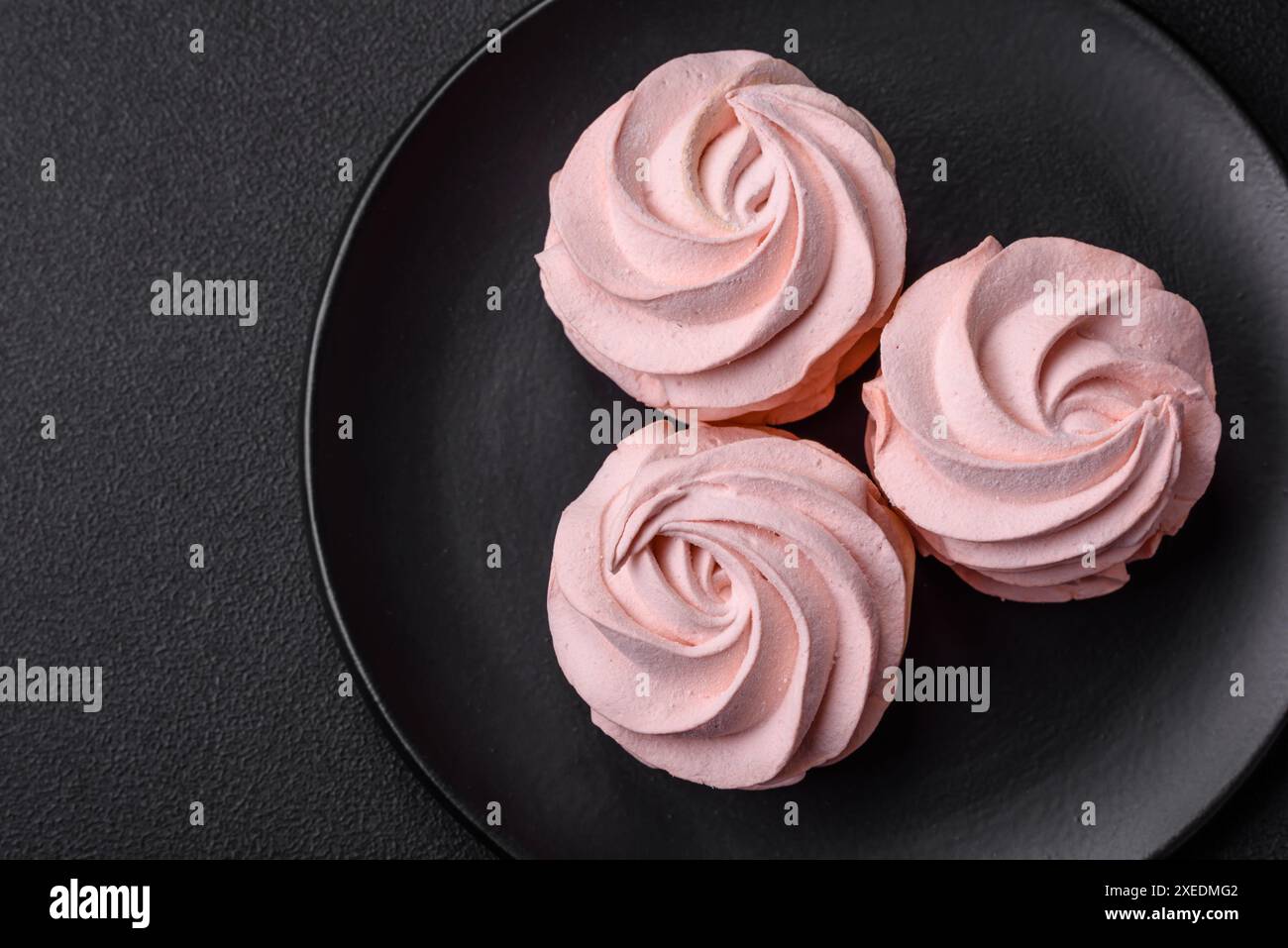 Köstlicher süßer Marshmallow auf dunklem Betonhintergrund Stockfoto