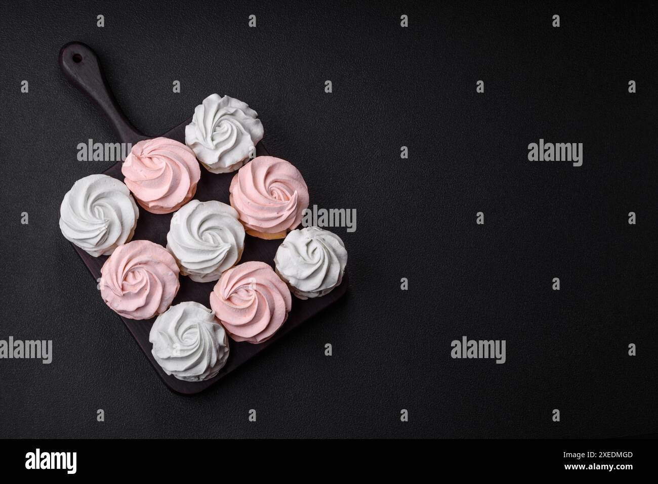 Köstliches süßes mehrfarbiges Marshmallow auf dunklem Betonhintergrund Stockfoto