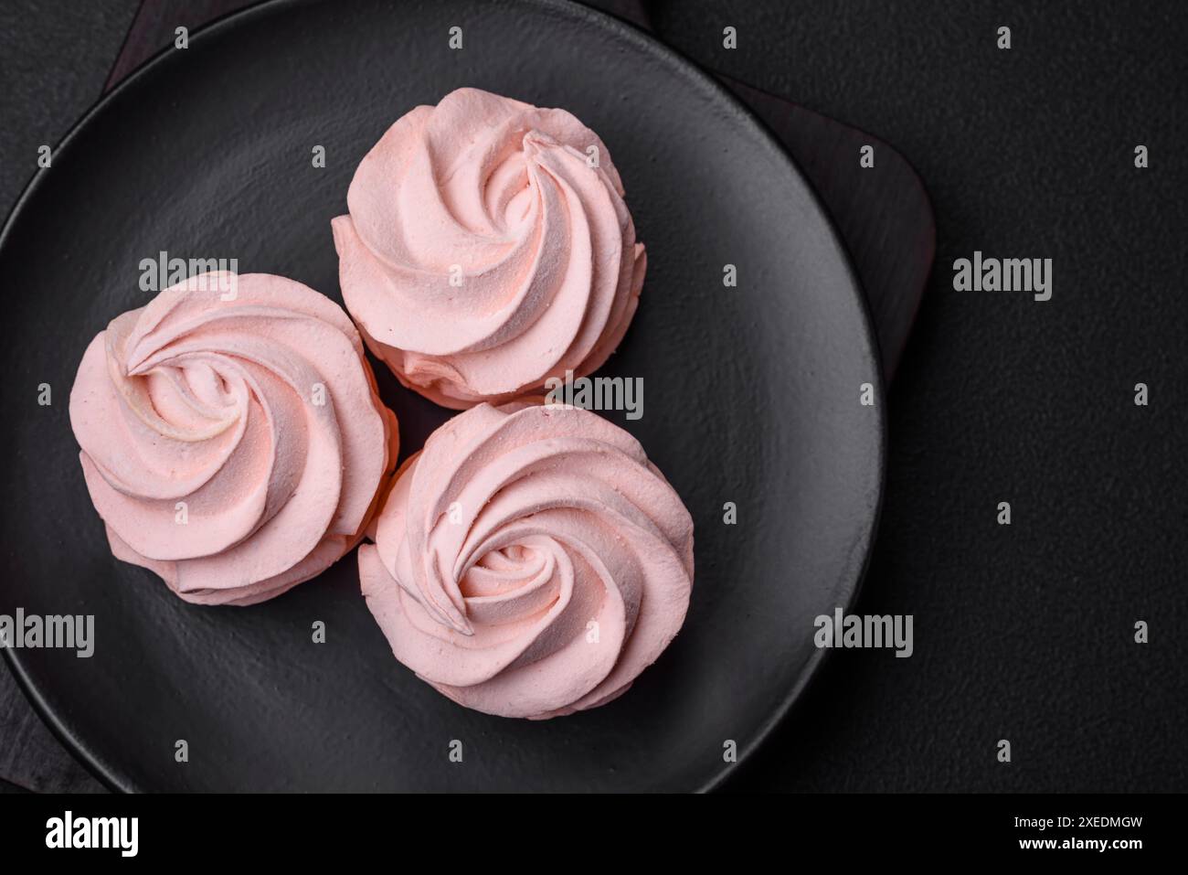 Köstlicher süßer Marshmallow auf dunklem Betonhintergrund Stockfoto