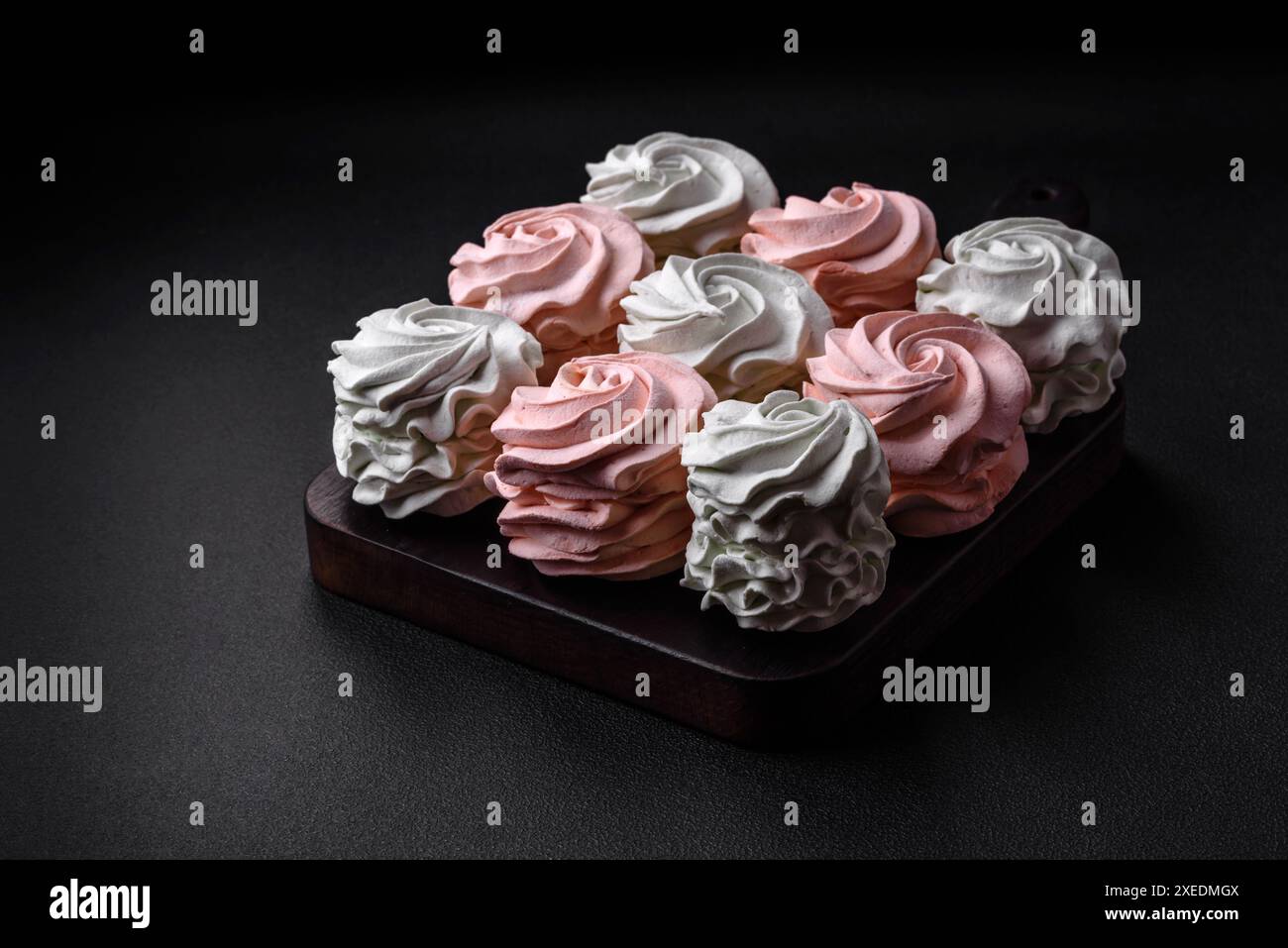 Köstliches süßes mehrfarbiges Marshmallow auf dunklem Betonhintergrund Stockfoto