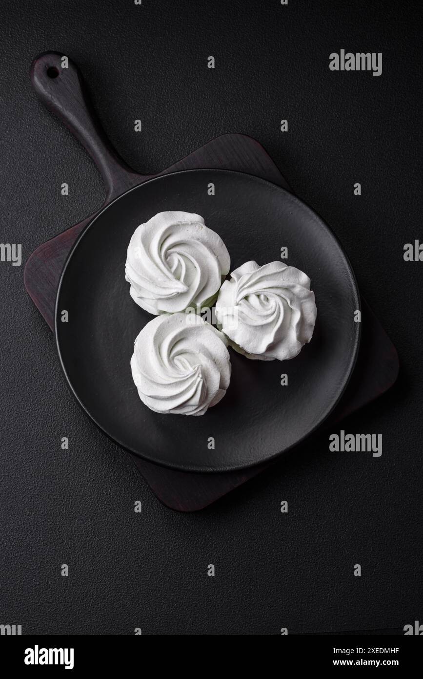 Köstlicher süßer Marshmallow auf dunklem Betonhintergrund Stockfoto