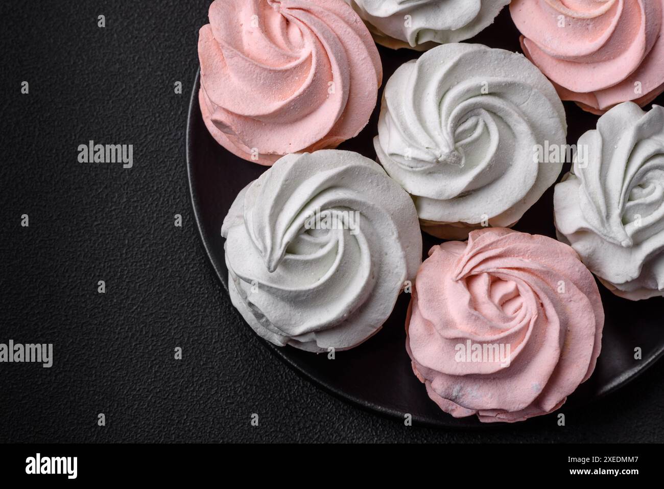 Köstliches süßes mehrfarbiges Marshmallow auf dunklem Betonhintergrund Stockfoto