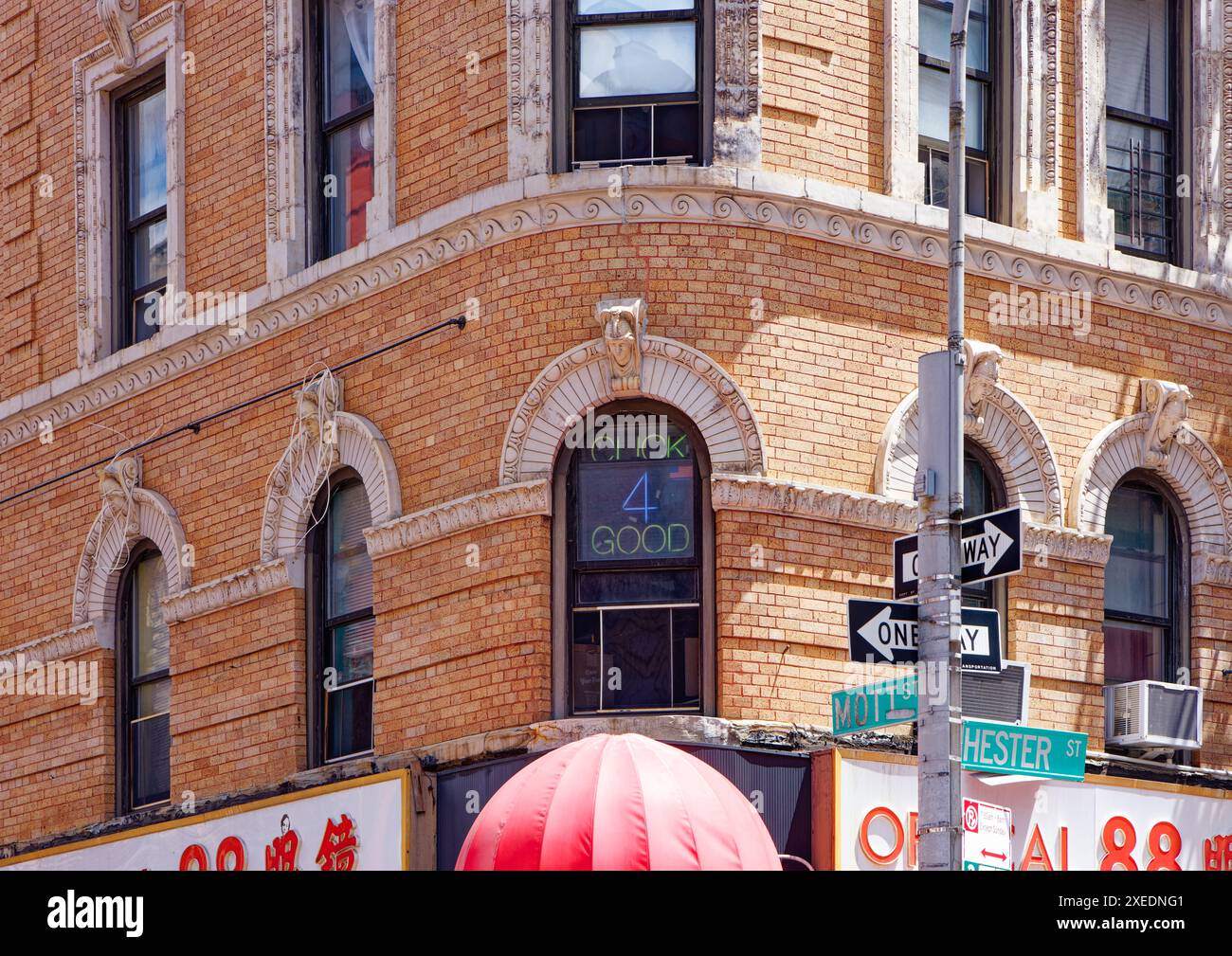 NYC Chinatown: 116 Mott Street, ein sechsstöckiges, begehbares Apartmentgebäude, hat eine abgerundete Ecke und weiße Terracotta-Details an der orangen Backsteinfassade. Stockfoto