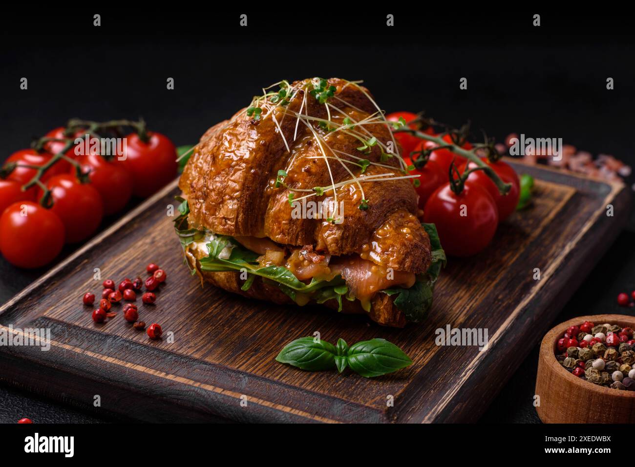 Köstliches knuspriges Croissant mit Lachs, Salat, Käse und Tomaten Stockfoto