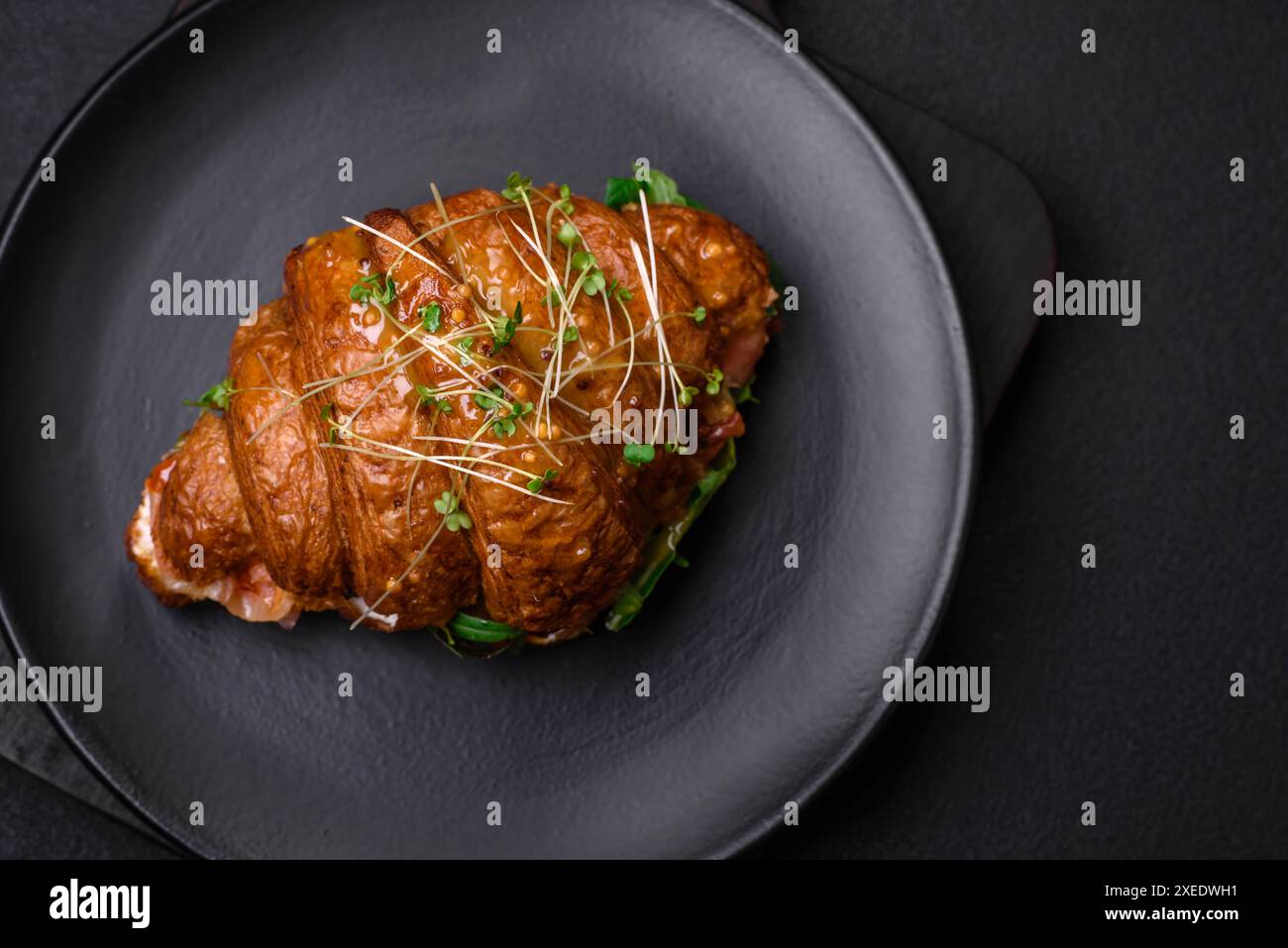 Köstliches knuspriges Croissant mit Lachs, Salat, Käse und Tomaten Stockfoto