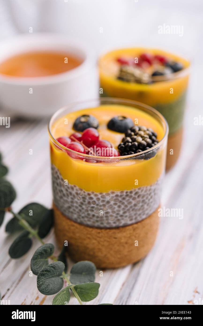 Gesunder veganer Chia-Pudding mit Mangohauce und frischen Beeren Stockfoto