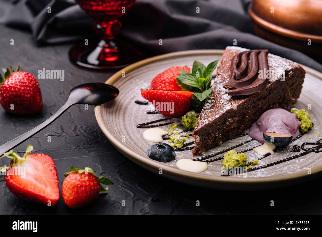 Brownie-Kuchen mit einer Schaufel Vanilleeis und Erdbeeren Stockfoto