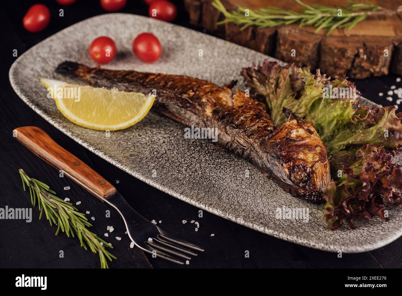 Fischgericht: Gegrillte Heringe mit Kirschtomaten Stockfoto