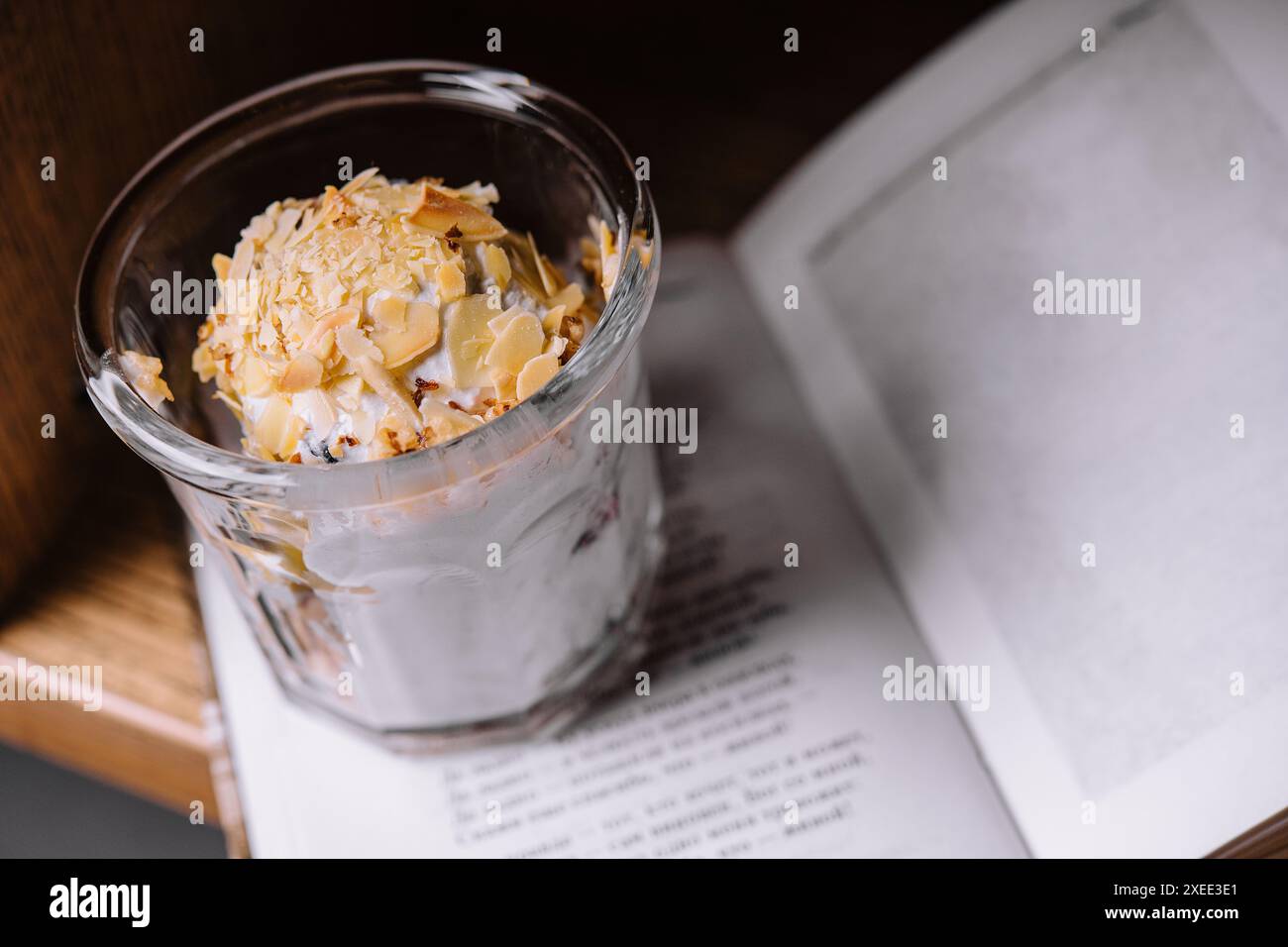 Eislöffel mit Mandeln und Buch Stockfoto