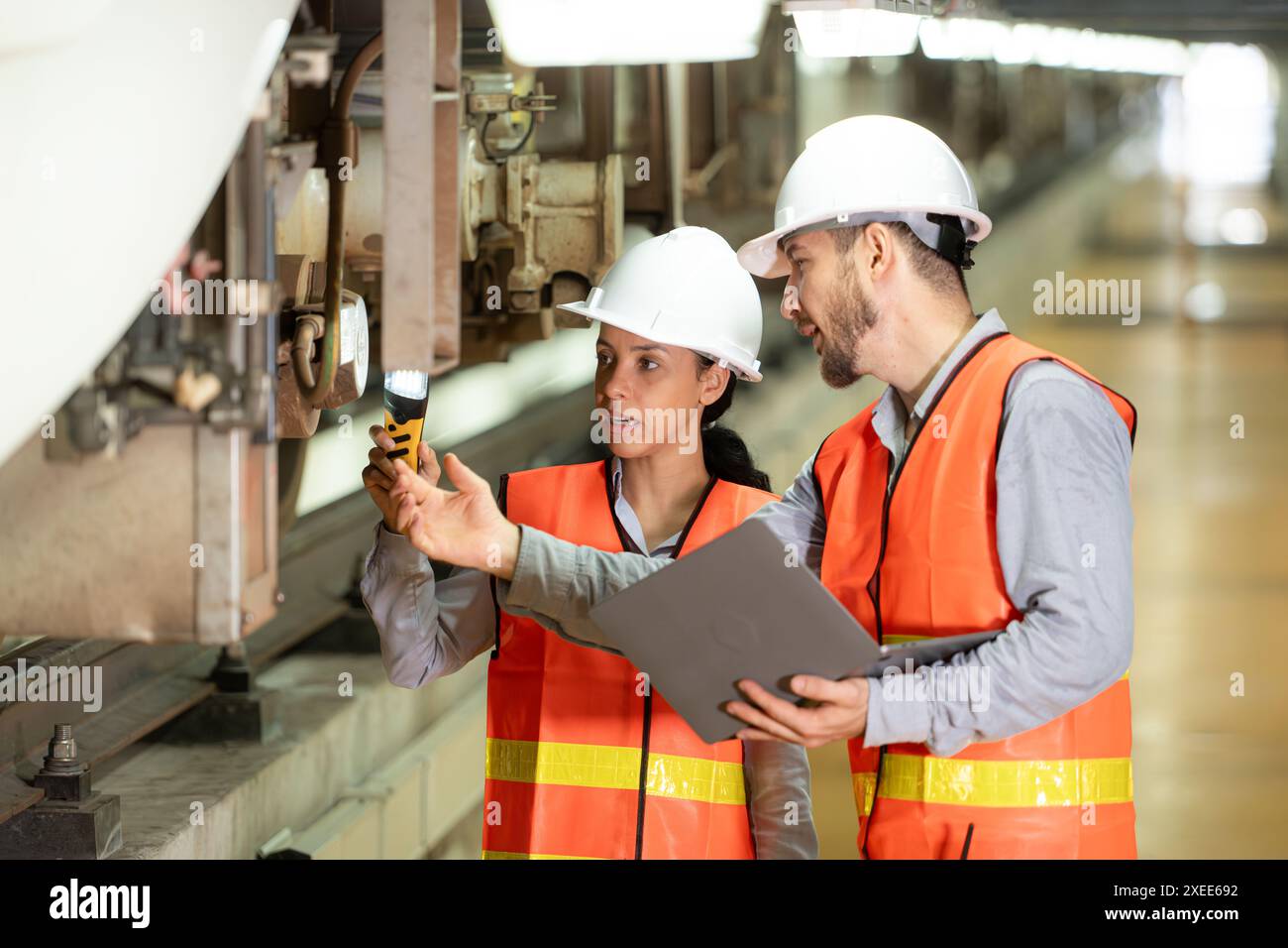 Ingenieure arbeiten in einer elektrischen Reparaturstation zusammen. Inspektion des Laufwerks von Elektrozügen, die b Stockfoto