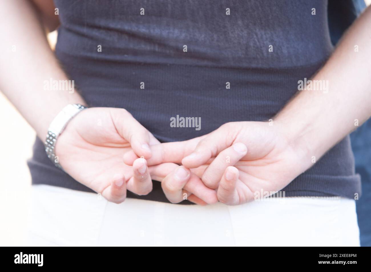 Nahaufnahme der Hände des Mannes, die in einer lässigen Pose zusammengeschlossen sind Stockfoto