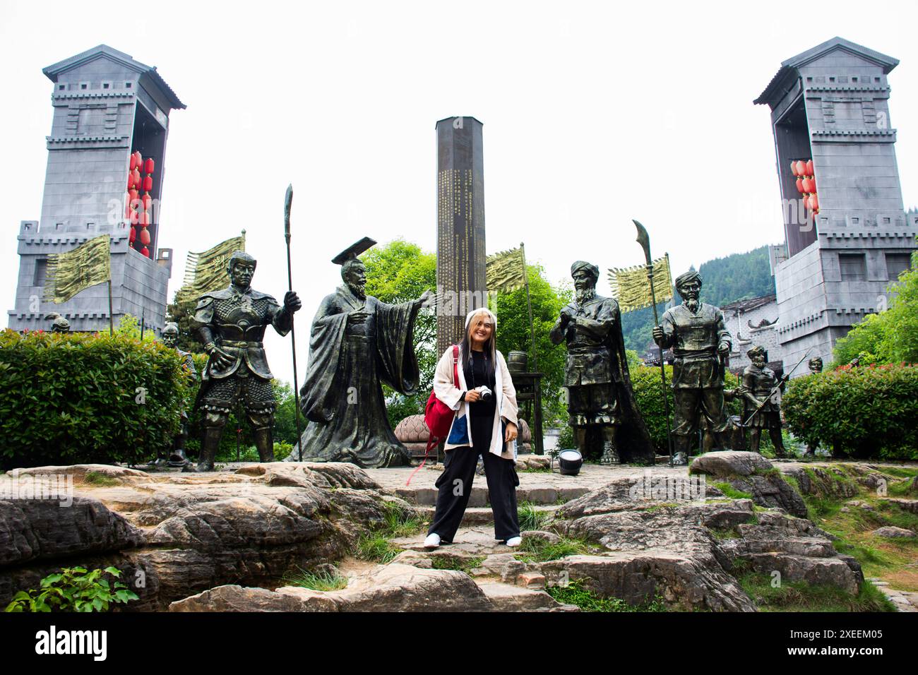 Thailändische Frauen reisen mit der antiken Statue Xizhou Säule des Tujia Stammes und Ma Xifan König von Chu mit Führer Xizhou in Furong Zhen Tujia an Stockfoto