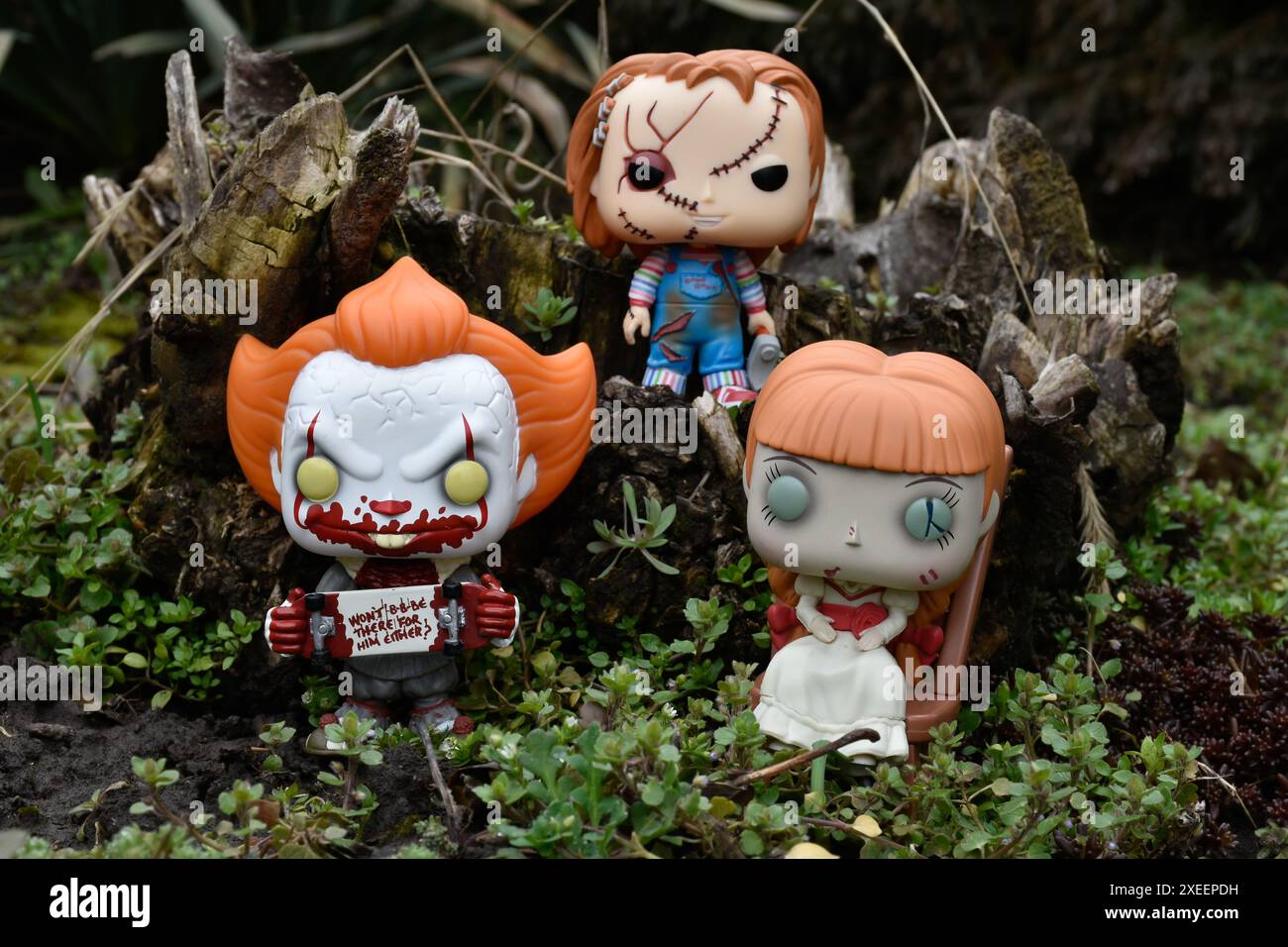 Funko Pop Actionfiguren aus Horrorfilmen. Pennywise böse Clown, gruselige Puppen Chucky und Annabelle. Moody, düster, gruseliger, dunkelgrüner Wald. Stockfoto