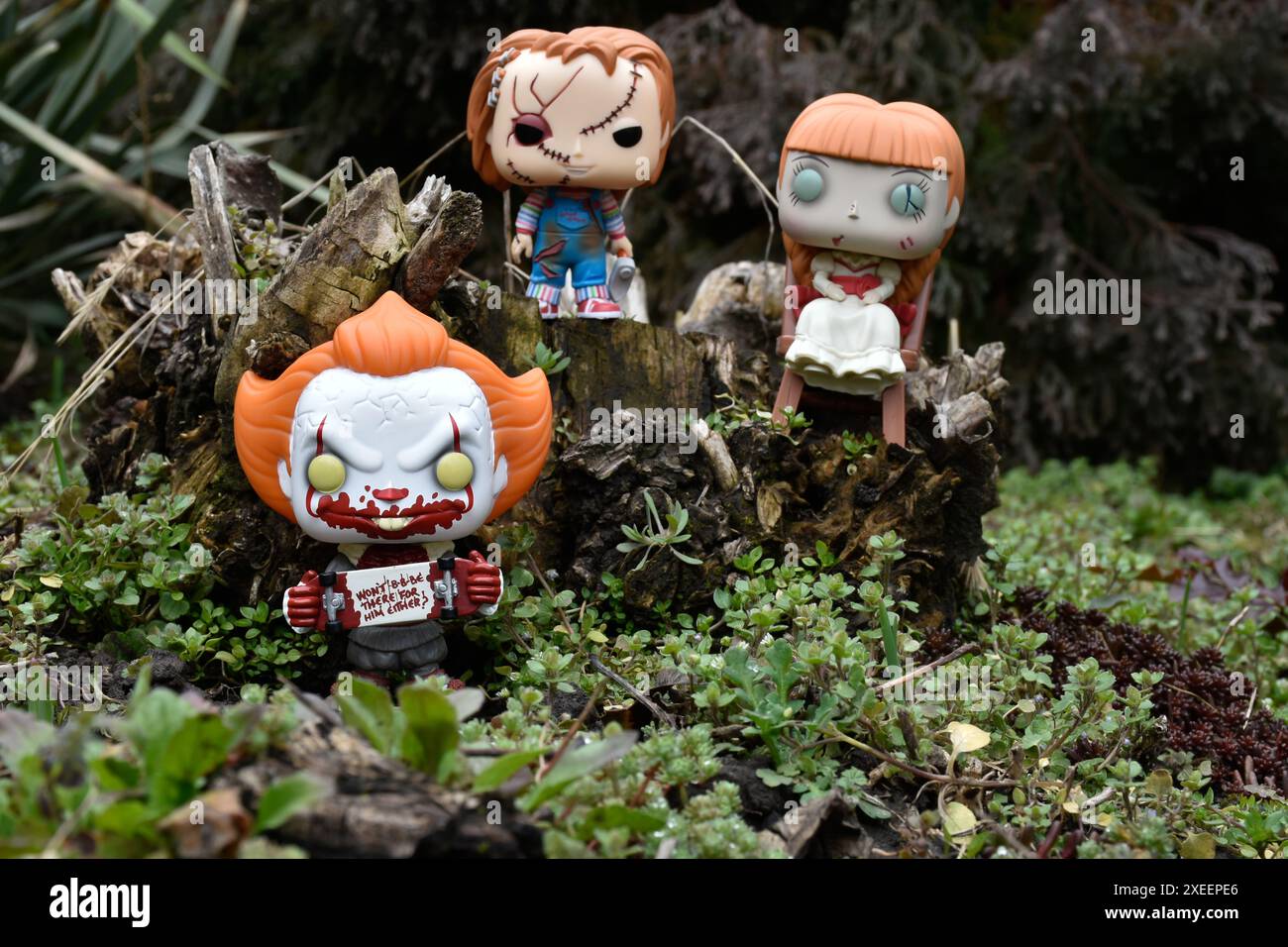 Funko Pop Actionfiguren aus Horrorfilmen. Pennywise böse Clown, gruselige Puppen Chucky und Annabelle. Moody, düster, gruseliger, dunkelgrüner Wald. Stockfoto