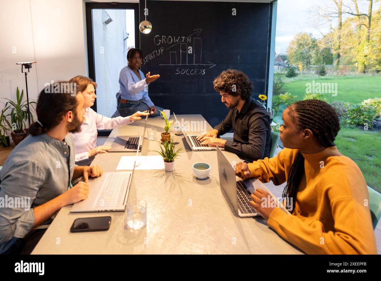 Energische Teamdiskussion in einem modernen Büro mit Strategie für das Schwarze Brett Stockfoto