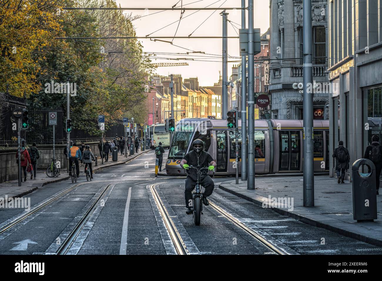 Radfahrer auf dem Elektrorad Radfahren an der Straßenbahnhaltestelle in St. Stephen's Green. Dublin. Irland. Stockfoto