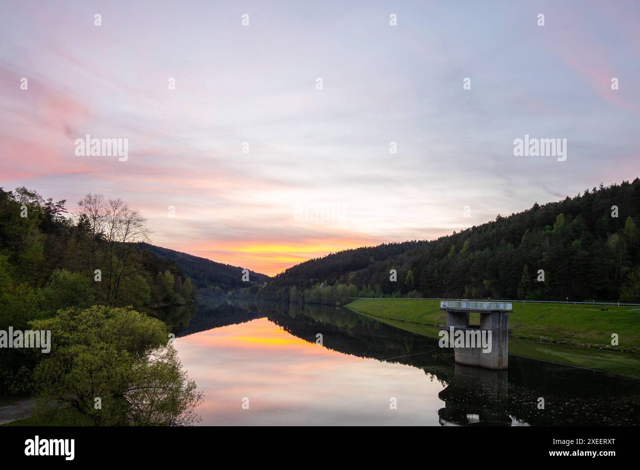 Sonnenuntergang auf einem ruhigen See in einem Tal umgeben von einem Wald Marbachstausee Stockfoto