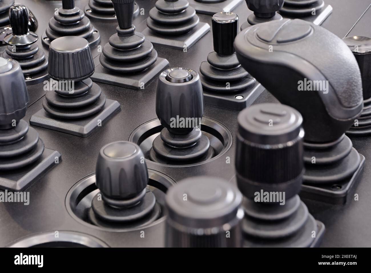 Eine große Gruppe von verschiedenen Steuerknüppeln auf einem schwarzen Armaturenbrett Stockfoto