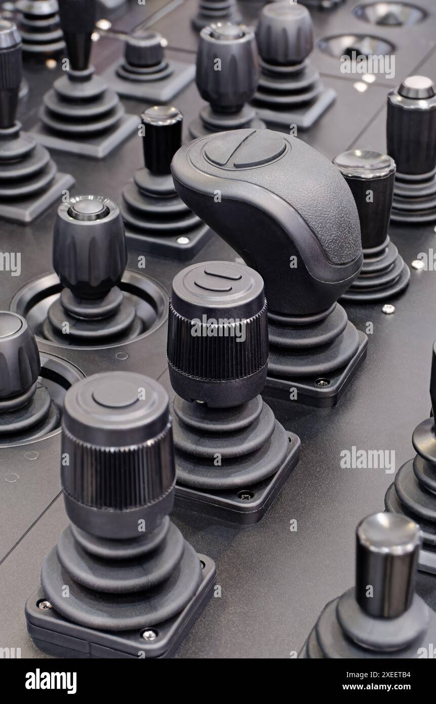 Eine große Gruppe von verschiedenen Steuerknüppeln auf einem schwarzen Armaturenbrett Stockfoto