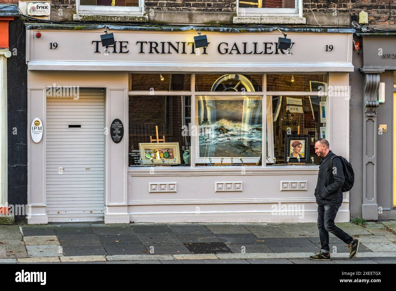 Ein Mann, der an der Trinity Gallery in der Clare Street vorbeiläuft. Dublin. Irland. Stockfoto
