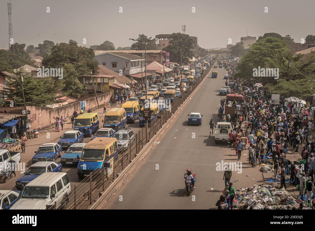Die überfüllte und geschäftige Straße von Bissau, der Hauptstadt von Guinea-Bissau in Westafrika, mit Menschen auf dem Markt, starkem Verkehr, Slums und lokalem Markt Stockfoto