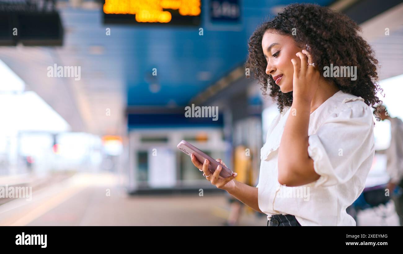 Geschäftsfrau Pendelt Auf Der Bahnplattform Musik Oder Podcast Vom Mobiltelefon Stockfoto