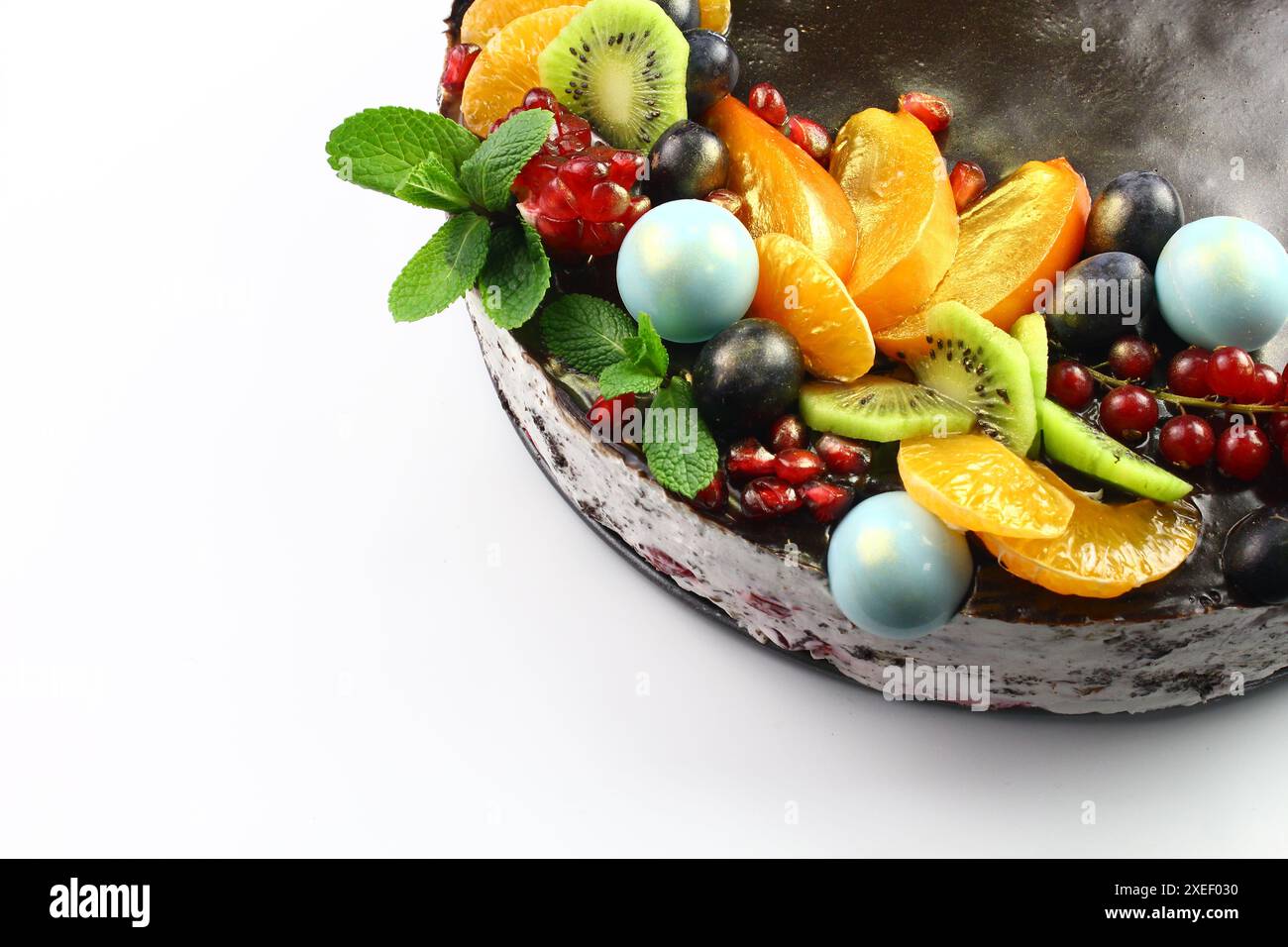 KIEW, UKRAINE Schokoladenkuchen, dekoriert mit Heidelbeeren, Keksen und Seifenblasen-Schokolade auf schwarzem Hintergrund. Brauner Frischkäse Stockfoto