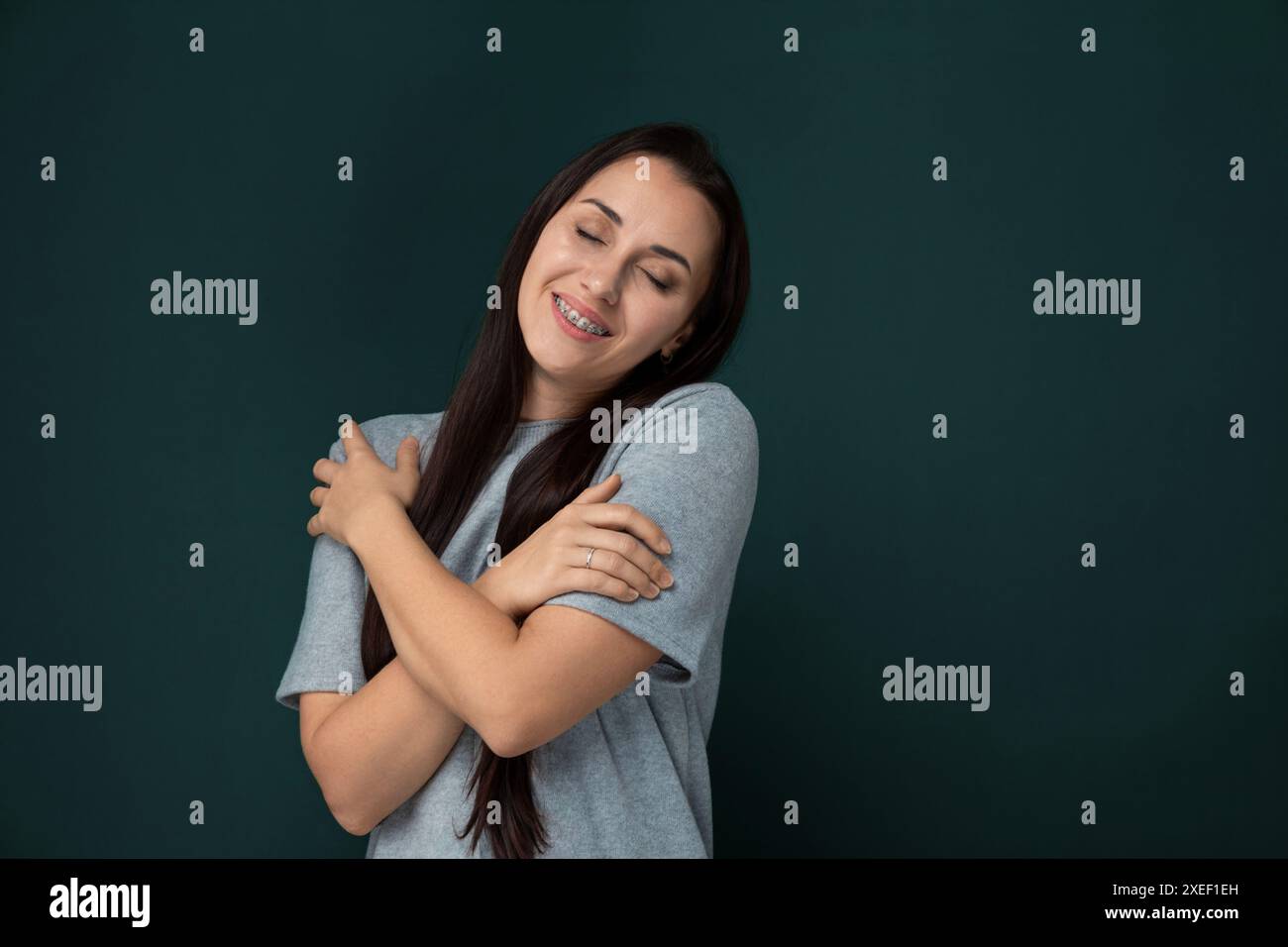 Lächelnde Frau Mit Gekreuzten Armen Stockfoto