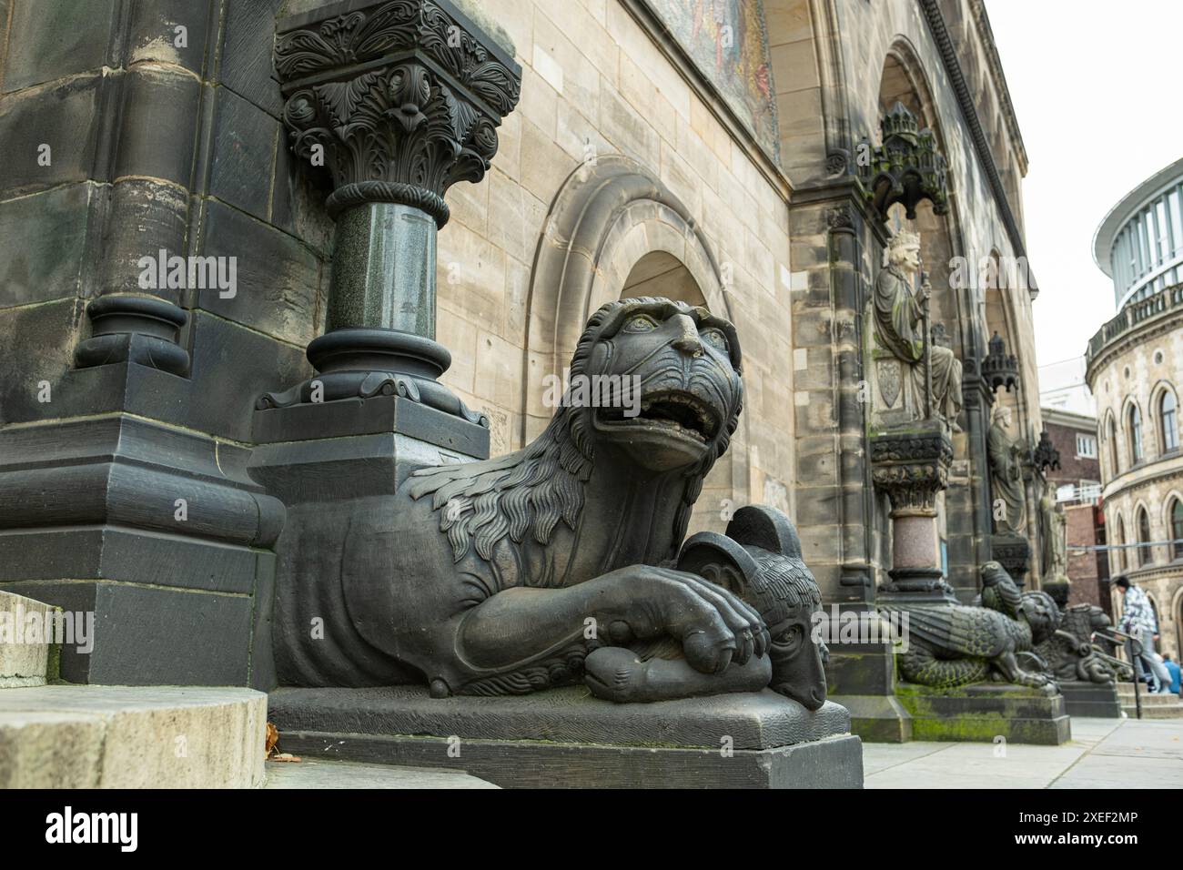 Ein dekoratives Monster aus Stein bewacht den Eingang zu einer alten mittelalterlichen katholischen Kathedrale. Wunderschöne Dekorationen und Basreliefs am Eingang Stockfoto