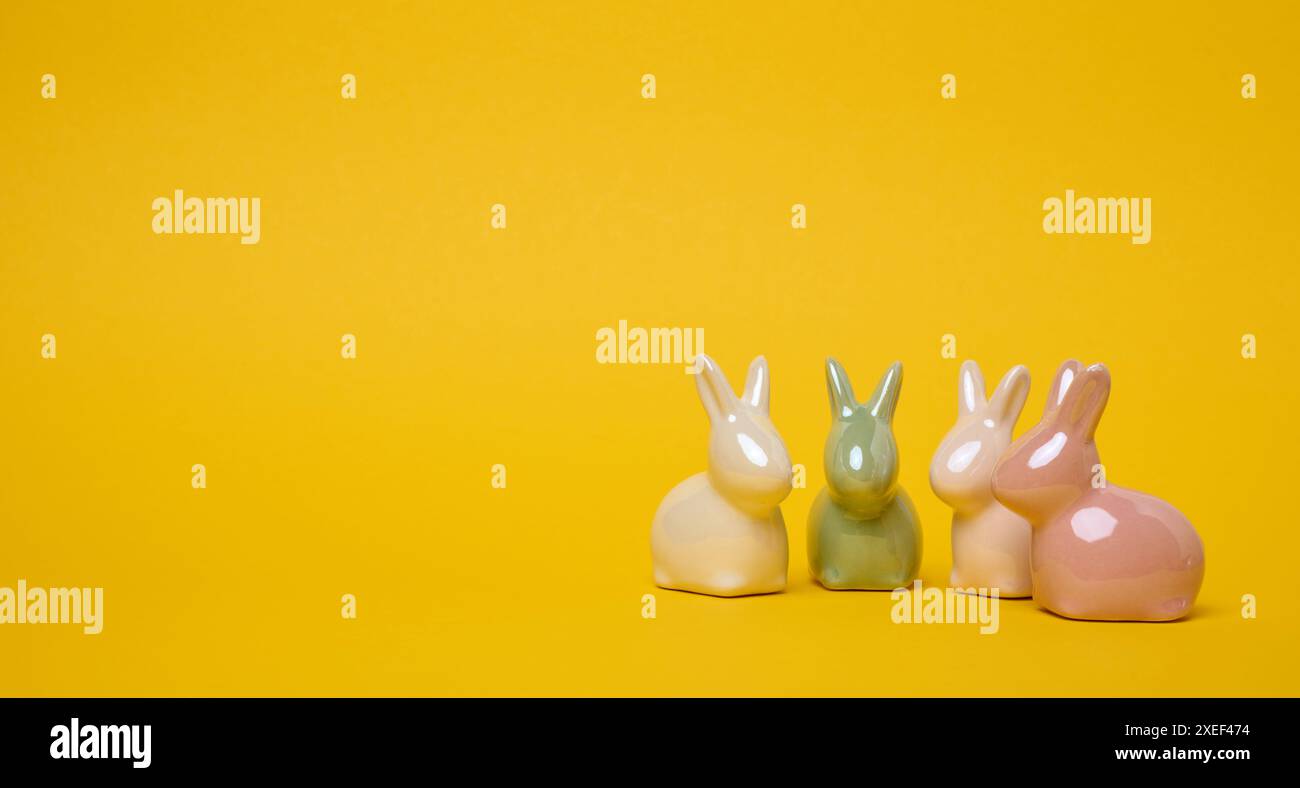 Dekorative Keramikhasen auf gelbem Hintergrund, festlicher Osterhintergrund Stockfoto