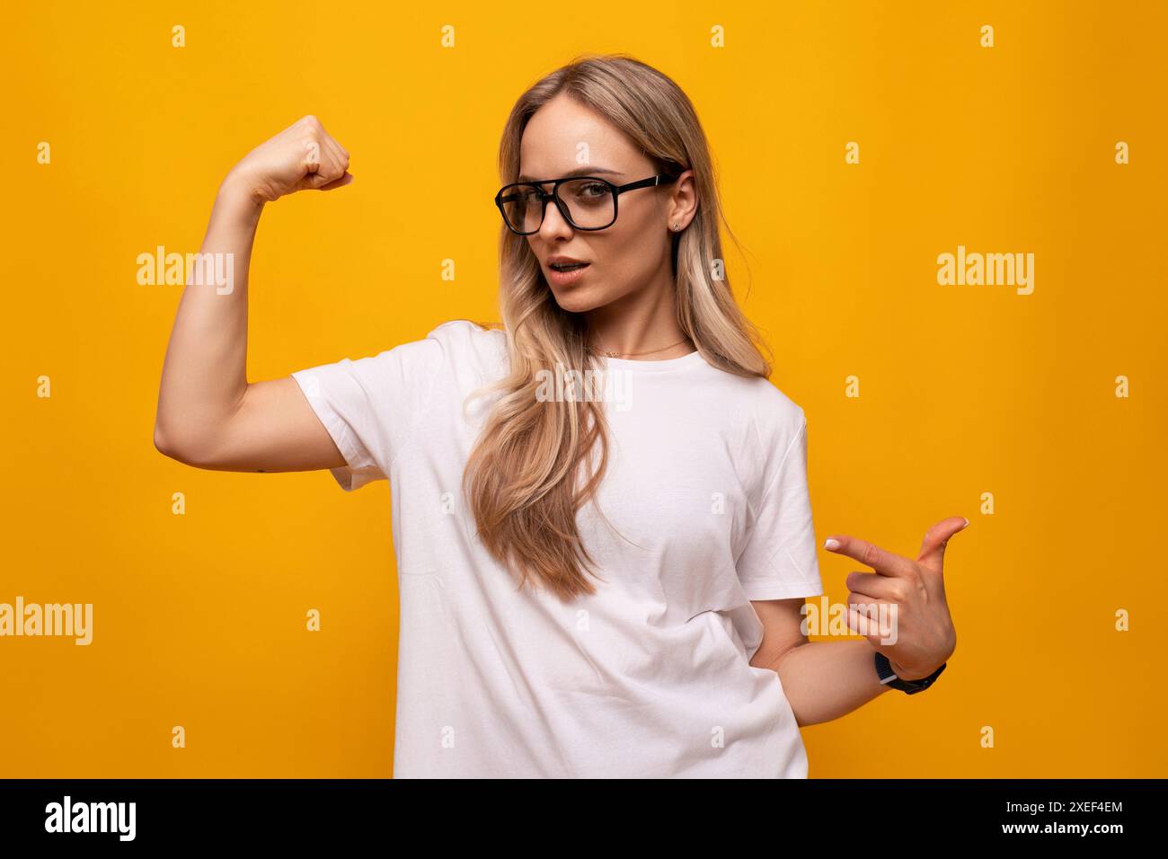 Mädchen in Brille und weißem T-Shirt auf gelbem Hintergrund Stockfoto