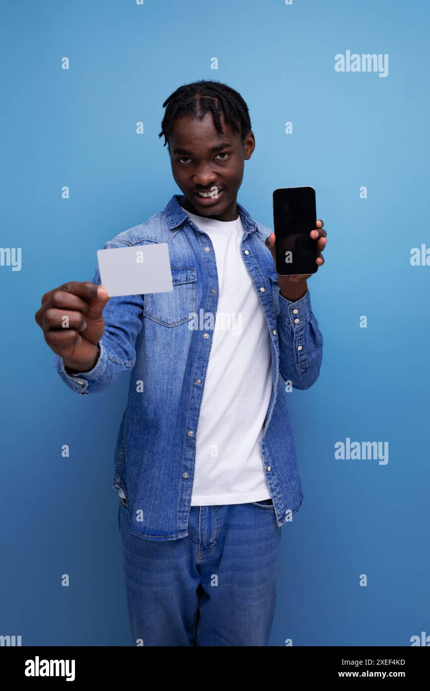 Stilvoller amerikanischer Mann mit schwarzen Dreadlocks, die Geldkartenmockup halten Stockfoto
