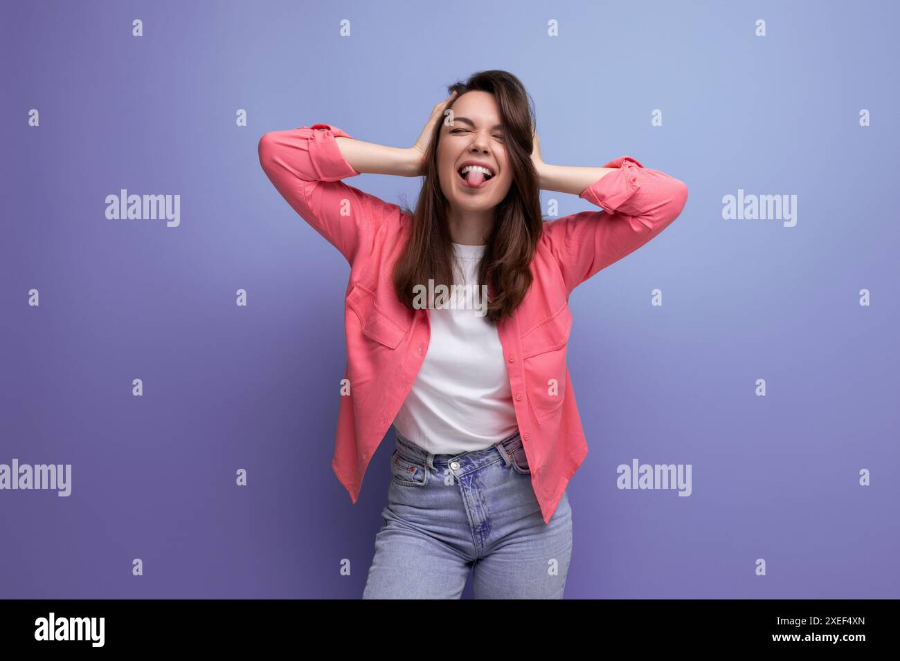 Gut gepflegte europäische Brünette 30er Jahre Frau in rosa Hemd auf Studiohintergrund Stockfoto