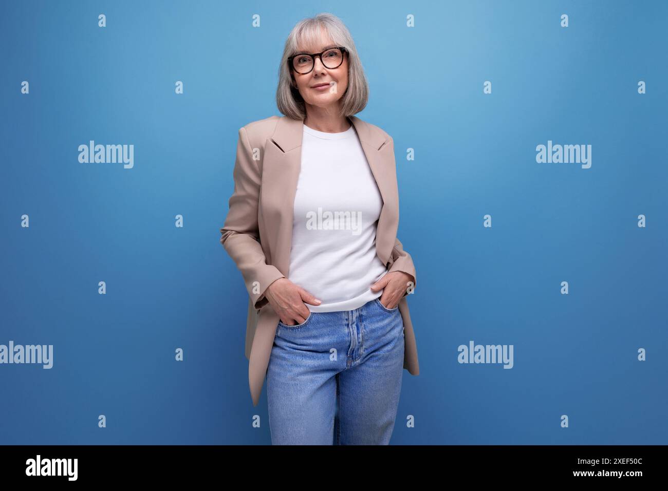 Erfolgreiche Geschäftsfrau der 60er Jahre im stilvollen Look auf Studiohintergrund mit Kopierraum Stockfoto
