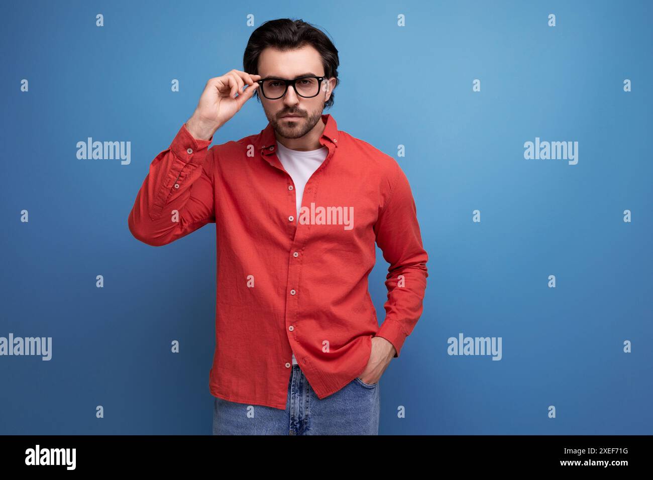 Überraschte weiße Brünette 30s Mann in einem roten Hemd mit Brille im Uki auf Hintergrund mit Kopierraum Stockfoto
