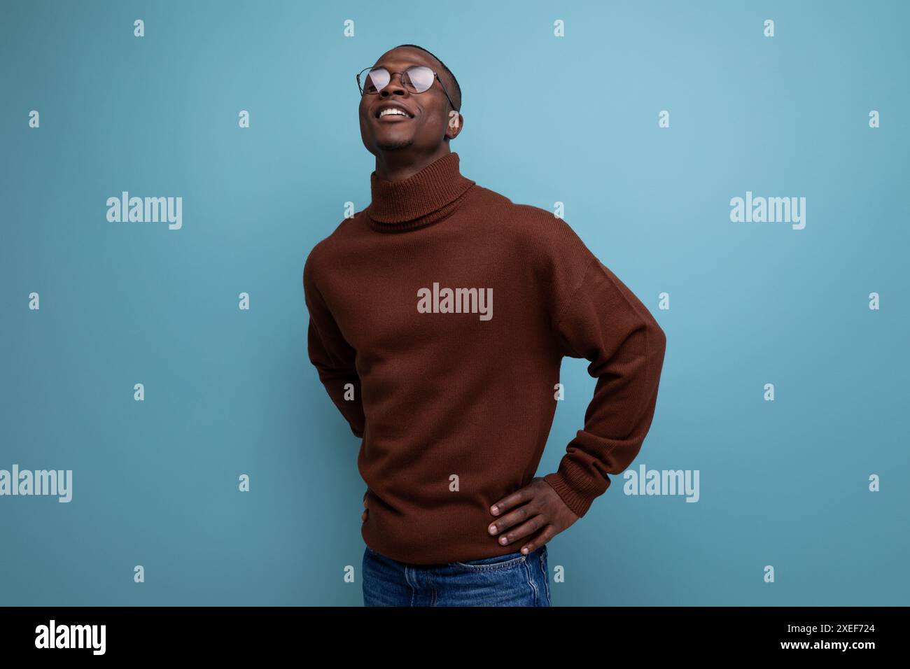 Porträt eines erfolgreichen jungen afrikanischen Mannes mit Modellerscheinung in einem braunen Pullover isoliert mit Kopierraum Hintergrund Stockfoto