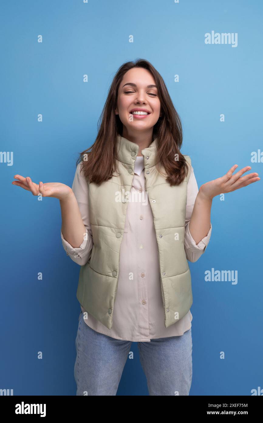 Positive, fröhliche, schwarzhaarige junge Dame in lässiger Kleidung über isoliertem Hintergrund Stockfoto