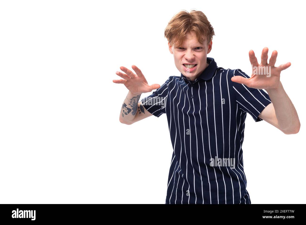 Emotionaler blonder Mann der 25er Jahre mit Tätowierungen, die grimmig sind Stockfoto