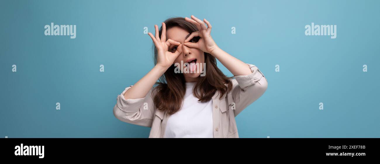 Panoramafoto einer fröhlich fröhlichen brünetten jungen Erwachsenen in Hemd und Jeans auf einem Hintergrund mit Kopierraum Stockfoto