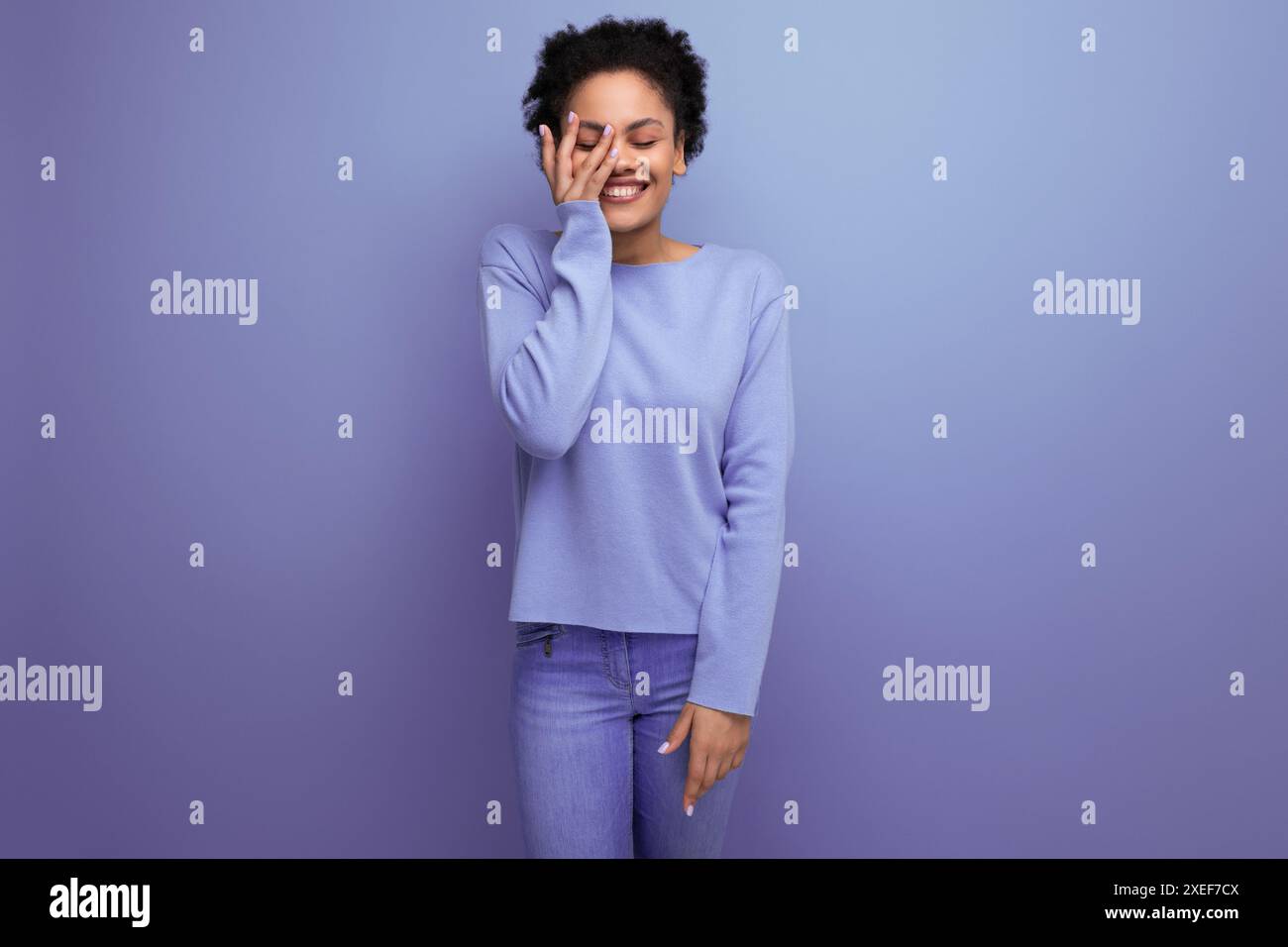 Charmante junge 20er-Frau mit Afro-Haaren in einem Bun-Modell-Aussehen auf dem Hintergrund mit Kopierraum Stockfoto