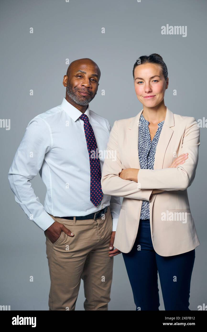 Studio-Porträt Eines Seriösen Geschäftsmannes Und Einer Geschäftsfrau In Anzügen Vor Weißem Hintergrund Stockfoto