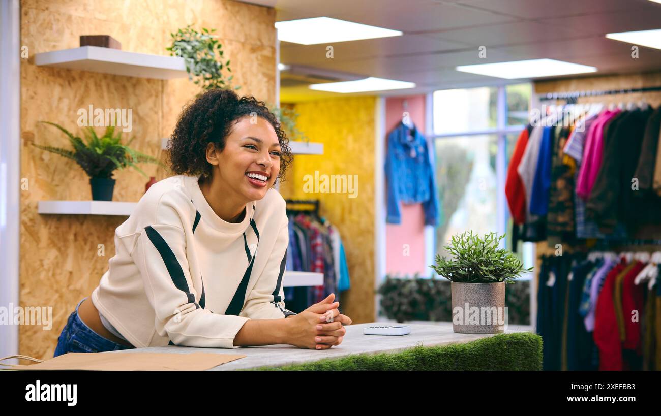 Lächelnde Verkäuferin An Der Kasse Im Pop-Up-Mode- Oder Kleiderladen Stockfoto