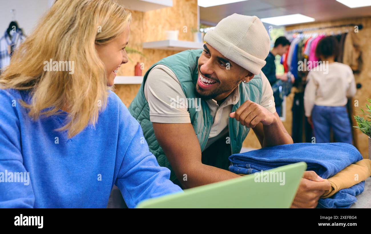 Verkäuferin Und Verkäuferin, Die An Der Kasse Mit Laptop Im Pop-Up-Mode- Oder Kleiderladen Arbeitet Stockfoto